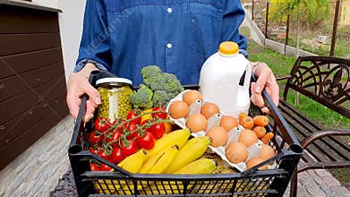 Woman carrying box with groceries after home delivery