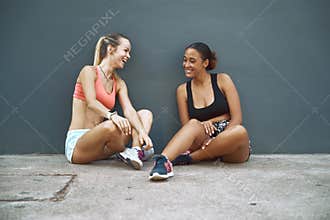 Laughing friends sitting outside taking a break from their worko