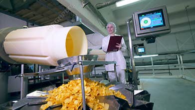 Unpacked crisps are being transported under control of a female worker