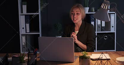 Businesswoman doing video conference late night at office