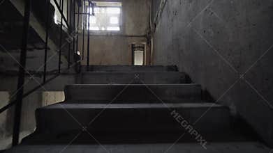 Climbing spooky stairs in darkness. Going up dark and dangerous stairs in creepy stairwell alone. slow motion