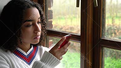 Sad biracial African American girl teenager young woman using her mobile cell phone or smartphone for social media