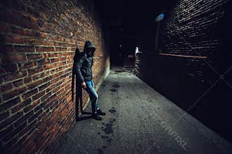 Suspicious man in dark alley waiting for something.