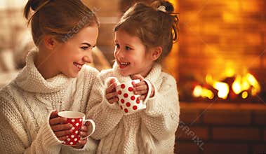 Family mother and child drinking tea and laughing on winter even