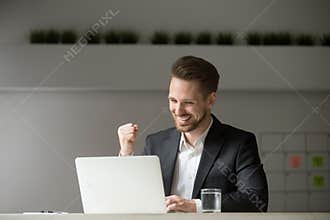 Happy businessman celebrating business success online win lookin