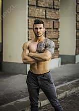 Muscular shirtless man in city centre
