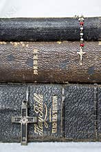 Close Up Three Antique Bibles and Crosses on White Background