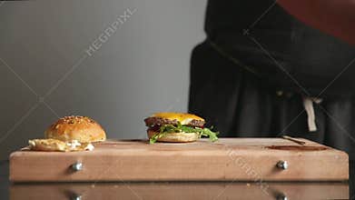 A professional chef prepares a cheeseburger with a big chop and a salad. Time laps.