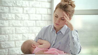 Unhappy woman holding sleeping baby on hands. Stress mother concept
