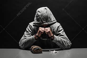 The drug addict was arrested for drug use at the table. suffering from addiction on a dark black background.