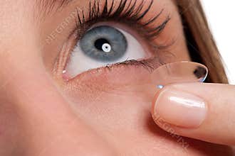 Blue woman eye with contact lens applying