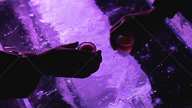 Hands taking cold glasses with beverage and drinking to bottom, original ice bar