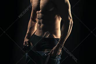 Mens heals care. Muscular torso, chest, belly on black background
