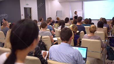 Education classroom blur background of university students sitting in a lecture hall or seminar room with teacher. View