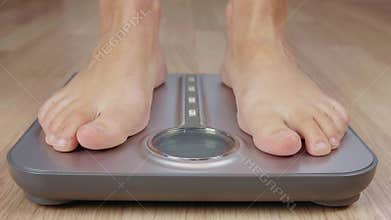 Human foot stepping on weighting scale for body mass control while losing weight