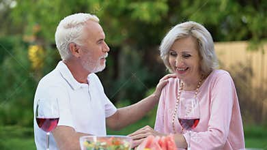 Seniors sitting at table and remembering their life together, happy marriage