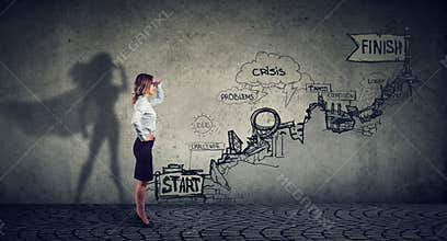 Businesswoman imagining to be a super hero looking aspired making career plans