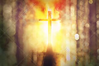 Silhouette of burning cross with rays of sunlight