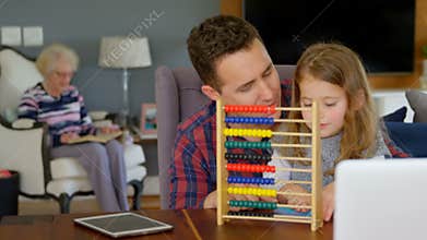 Father and daughter playing with abacus in living room