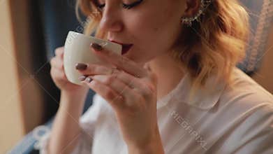 Woman drinks tea cup in cafe