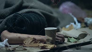 Homeless vagabond sleeping on cold night city street, refugee seeking asylum