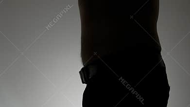 Close-up of a large male belly. Silhouette of a man with a big belly on a white background. A fat man draws in his