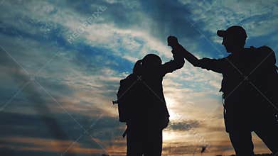 Teamwork business journey concept win. happy family team tourists man and woman sunset silhouette help shake hands