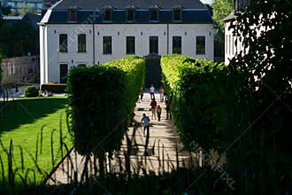 Brussels, Belgium - May 6 2018: La Cambre Abbey park on sunny day with people amongst row of trees