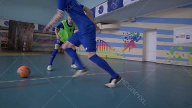 Soccer training, sport team of teenagers football players pass ball to score goal at sports hall