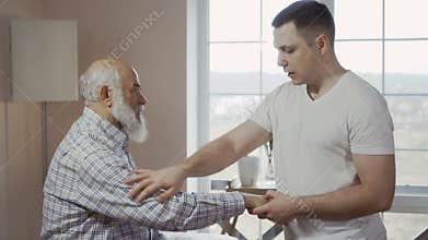 Masseur warms up a man hand before massage