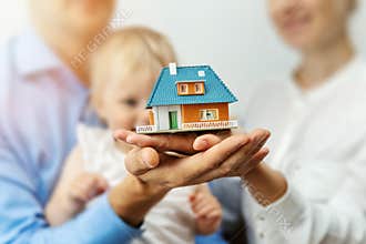 New home concept - young family with dream house scale model