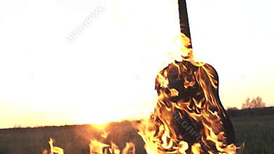 Burning acoustic guitar on fire close up