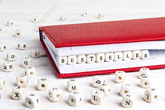 Word Bestseller written in wooden blocks in red notebook on whit