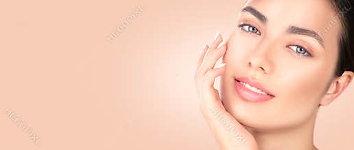 Beautiful brunette girl touching her face. Perfect fresh skin. Spa beauty portrait. Youth and skincare concept