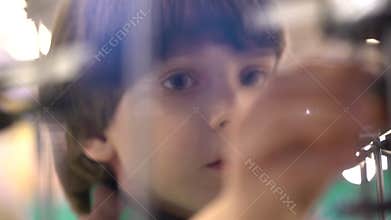 Child and robot: an inquisitive boy at an exhibition of robots. Modern toys. Children and the future. Virtual games