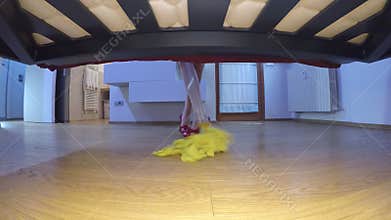 Woman in high heels washes the floor under the bed
