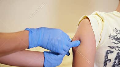 Doctor injecting flu vaccine to patient`s arm in local hospital