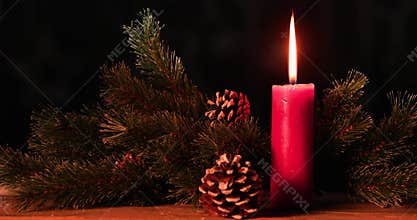 Christmas candle burning on the wooden table