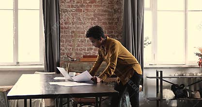 Serious African businesswoman do paperwork, analyze papers, review sales results