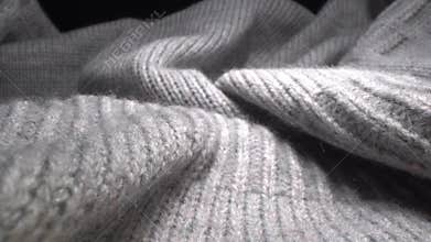 The texture of a soft warm cozy gray woolen knitted sweater