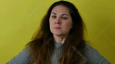 Portrait of an angry and indignant woman on a yellow background.