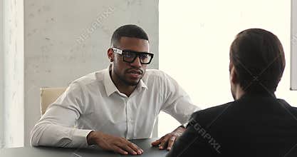 African businessman negotiates, speaks to business partner at meeting