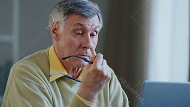Close up tired caucasian man indoor working with laptop elderly 60s male take off glasses rest from computer screen rubs