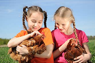 Two girls holding chickens