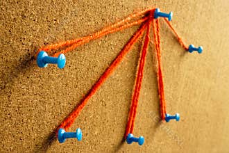 Pins on the board connected by a thread. Delegation concept.