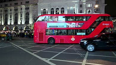 Red London Double Decker buses pass Police Officers and protesters at a Polish pro choice protest at Oxford Circus at night