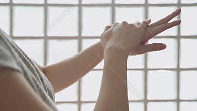 Asian woman applying lotion on hands at home studio. white cream scrubbing to treatment skin condition.