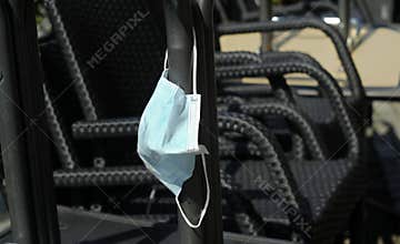 Face mask hanging on stacked chairs in a closed restaurant, food and drink business corona lockdown