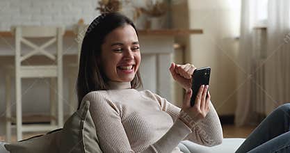 Happy millennial woman getting email with win news.