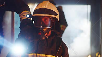 Fireman illuminating hallway with flashlight